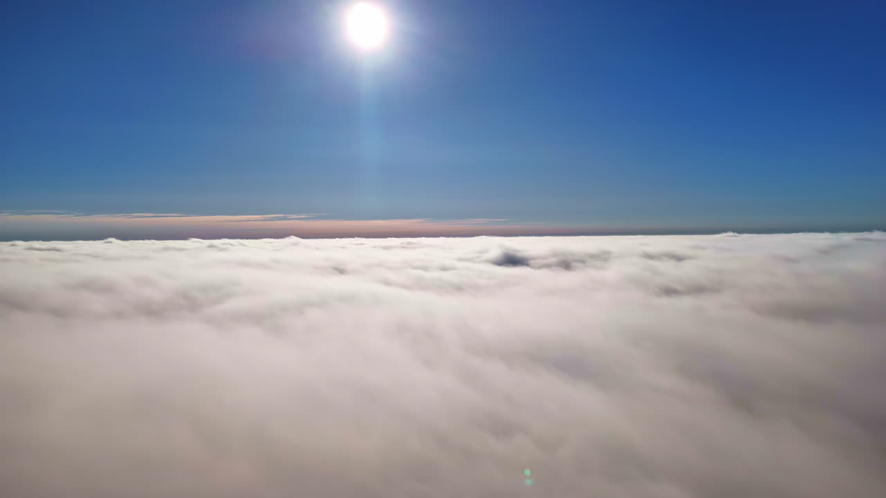 Sunny sky above fluffy clouds creates peaceful and serene atmosphere