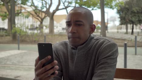 serious man having video conversation via smartphone