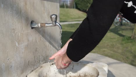 washing hands at fountain