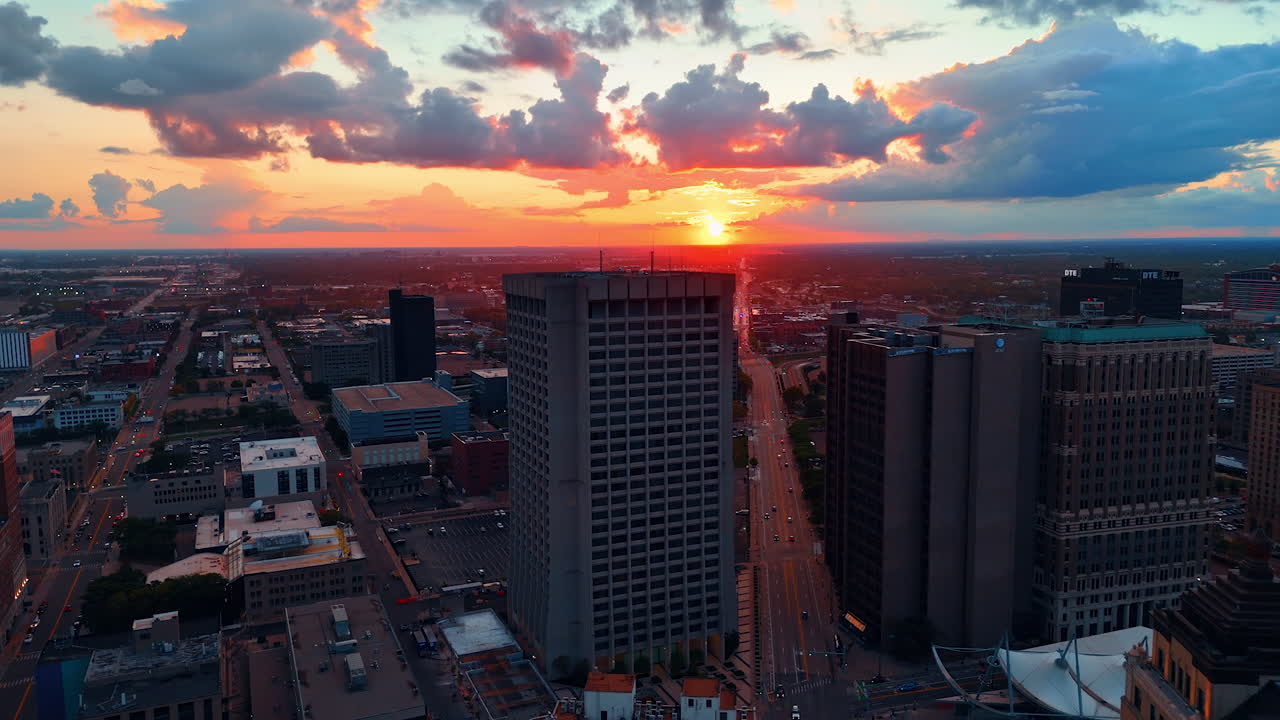 Detroit, USA, 28 July 2025: Golden hour orange sunlight colors the city scenery. Fluffy clouds hang in the sky. Sunset in Detroit, Michigan, USA