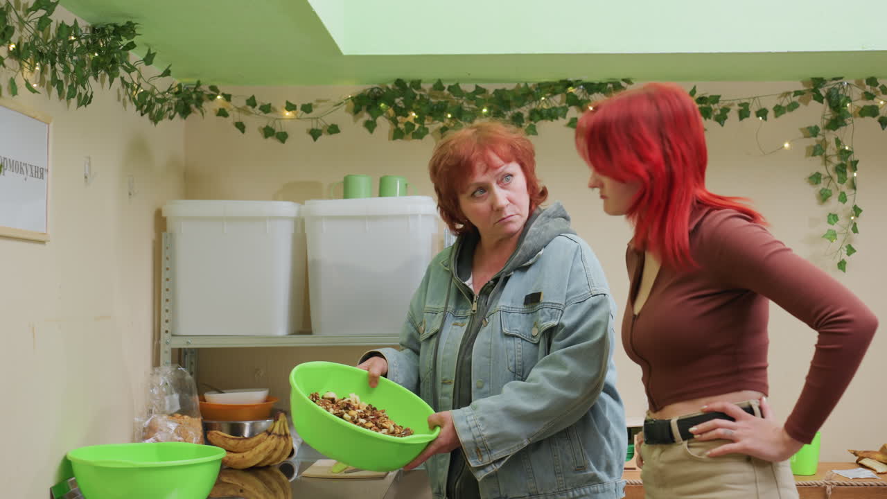 Femme blanche tendant un bol vert, démonstration de produit et inspection minutieuse dans une boutique de plantes, propriétaire encadrant un apprenti avec des expressions attentives, présentation pratique au comptoir, lierre d’intérieur et lumières chaudes