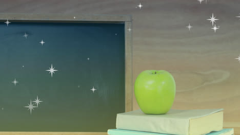 Animación-De-Estrellas-Sobre-Manzana-Con-Libros-Y-Pizarra.