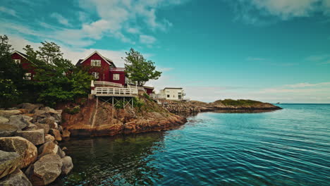 rocky coastline in the lofoten islands, norway. view of the still norwegian sea, and the wooden ren cabins located on the coastline.