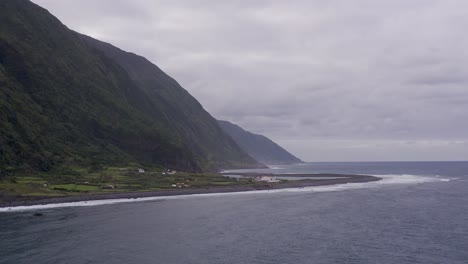 coastal-rural-village,-a-lagoon,-with-lush-green-cliffs-landscape,-Fajã-de-Santo-Cristo,-São-Jorge-island,-the-Azores,-Portugal