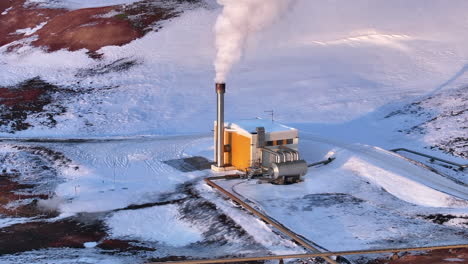 Aerial-close-up-of-a-geothermal-power-plant-in-Myvatn-during-winter,-steam-rising