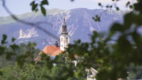 Kirche-Der-Muttergottes-Am-Blutenden-See-Zwischen-Blättern,-Schwenk-Nach-Rechts,-Zeitlupe