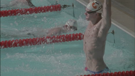 a winner stands in victory after swimming to the finish line