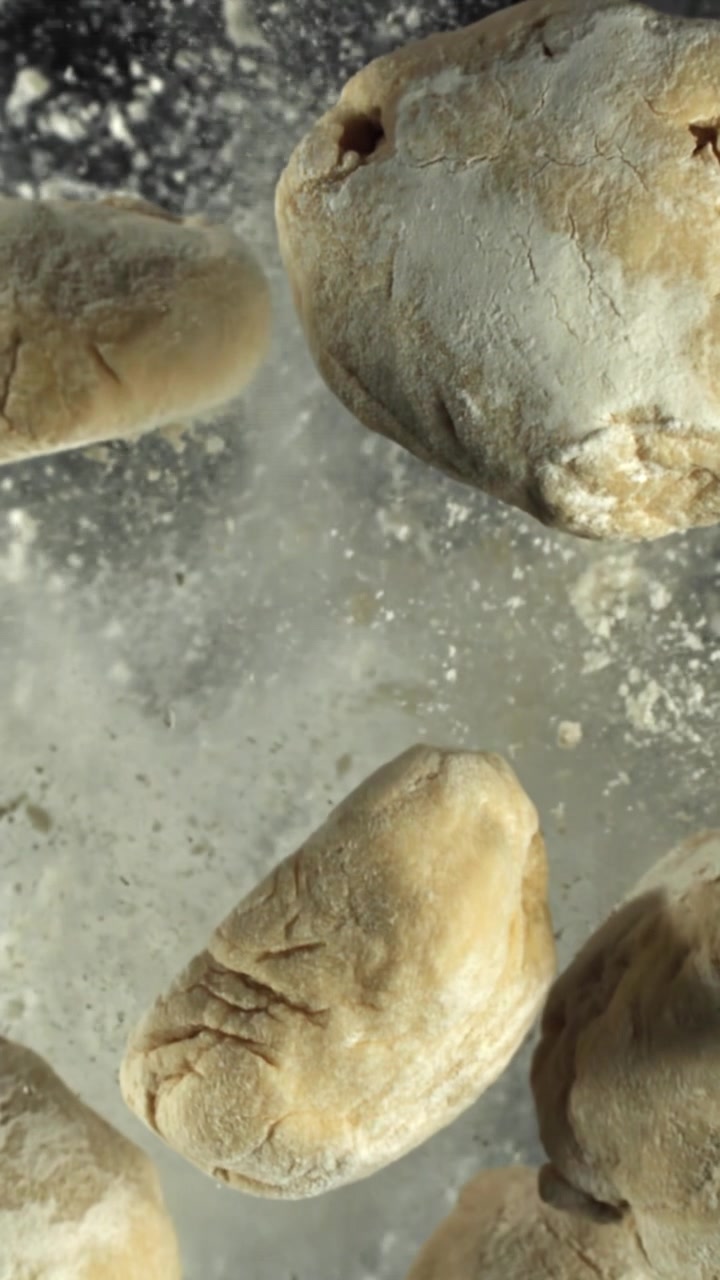 Raw Dough Pieces Falling with Flour in Slow Motion