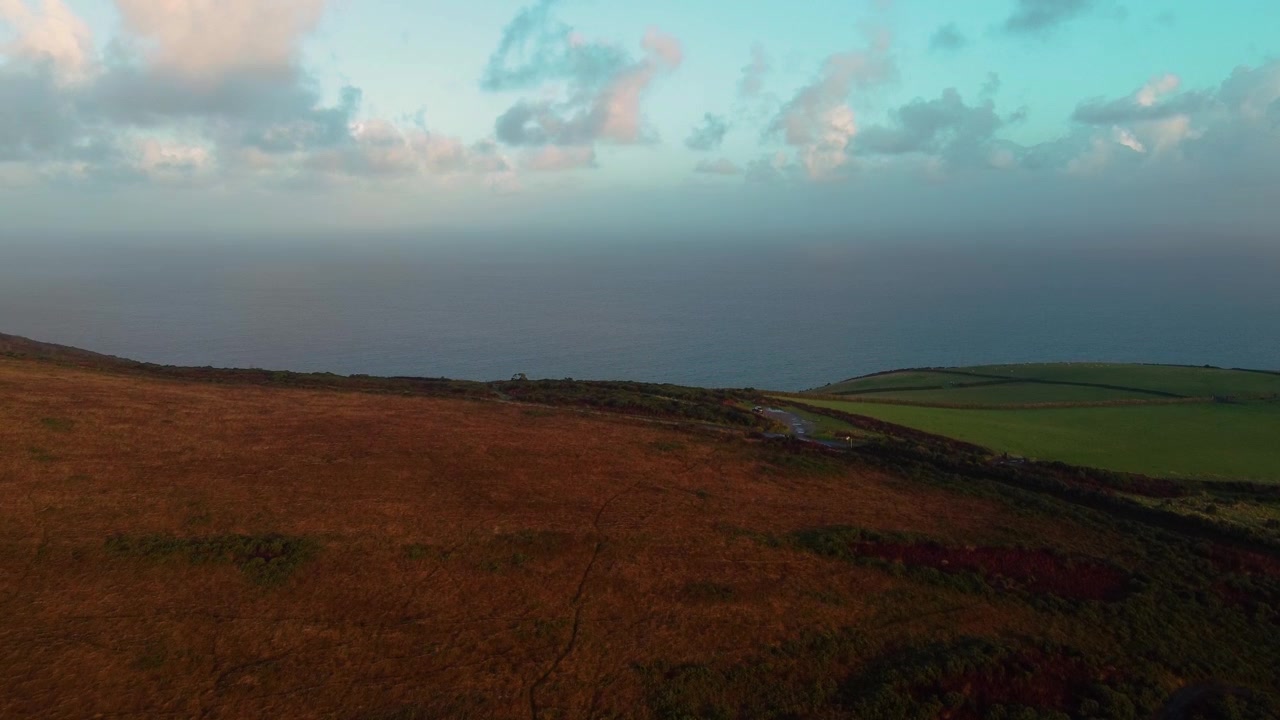 Sabah Gün Doğumu sırasında, Bulutlu Güzel Gökyüzü ile Exmoor üzerinden Bristol Kanalı Okyanusu'na doğru Yükselen Havadan Görüntü 4K