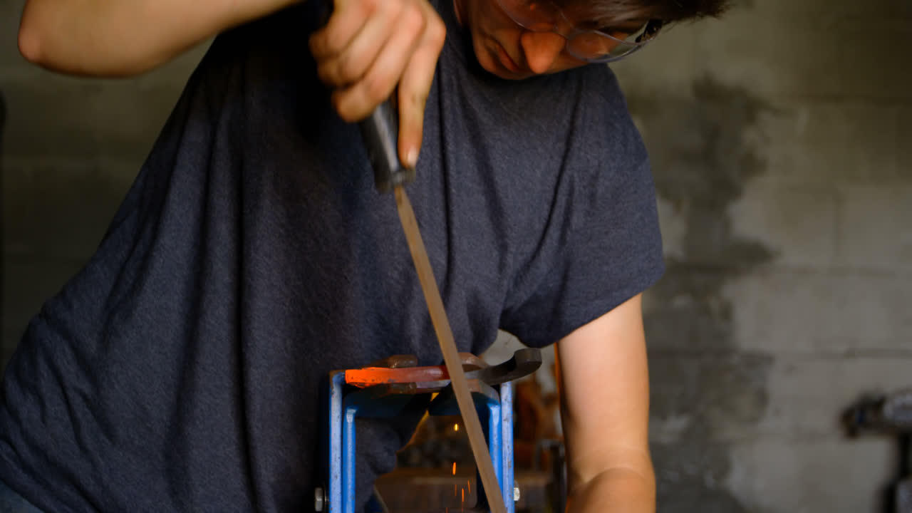 Female metalsmith shaping horseshoe in factory 4k