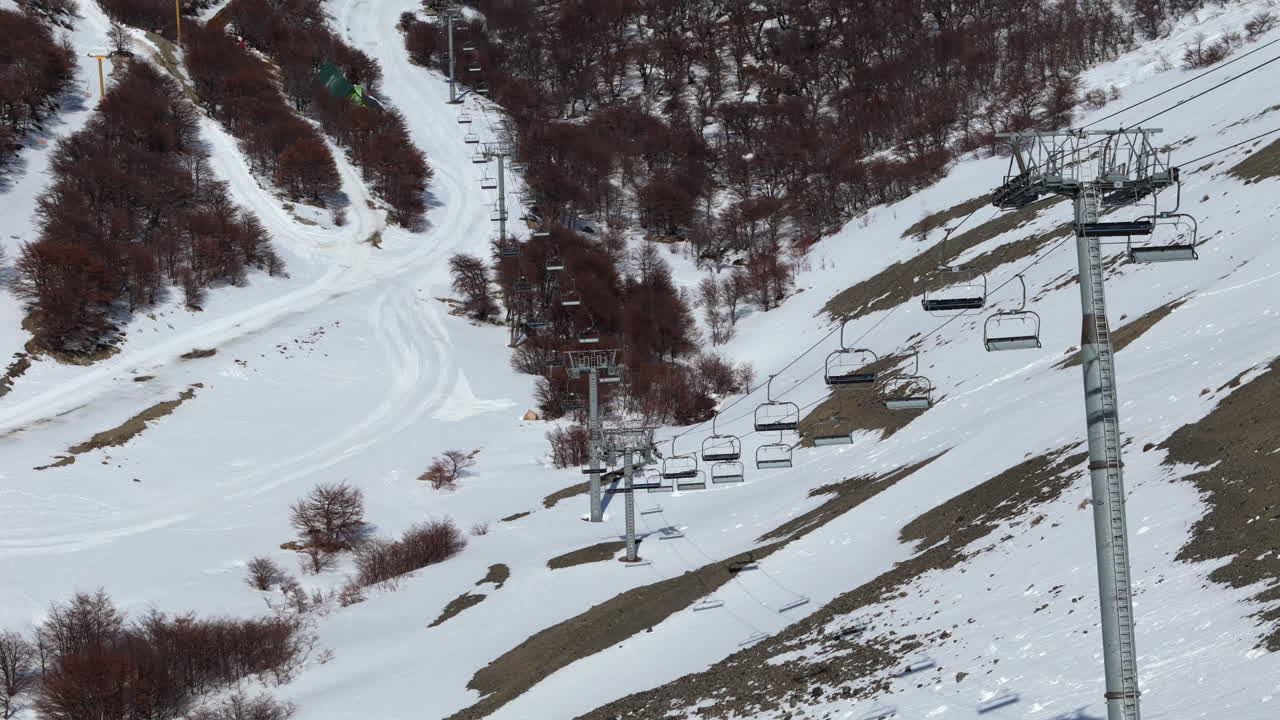 Upward tilting drone shot of stalled chair lifts at La Hoya Ski resort in Esquel, Argentina. 4K-60fps.