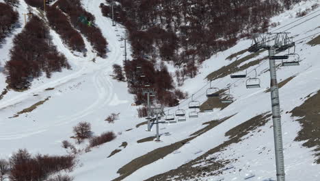 Upward tilting drone shot of stalled chair lifts at La Hoya Ski resort in Esquel, Argentina. 4K-60fps.