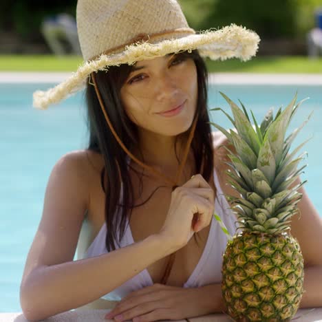 sunbathing beauty drinks from a pineapple