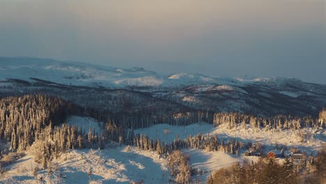 Amplia-Toma-Aérea-Del-Hermoso-Paisaje-Nevado-Con-árboles-Helados-Durante-La-Puesta-De-Sol-Dorada-En-Noruega