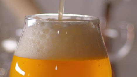 Slow-Motion-Close-up-of-craft-Beer-being-poured-in-to-a-tulip-glass,-bar-background