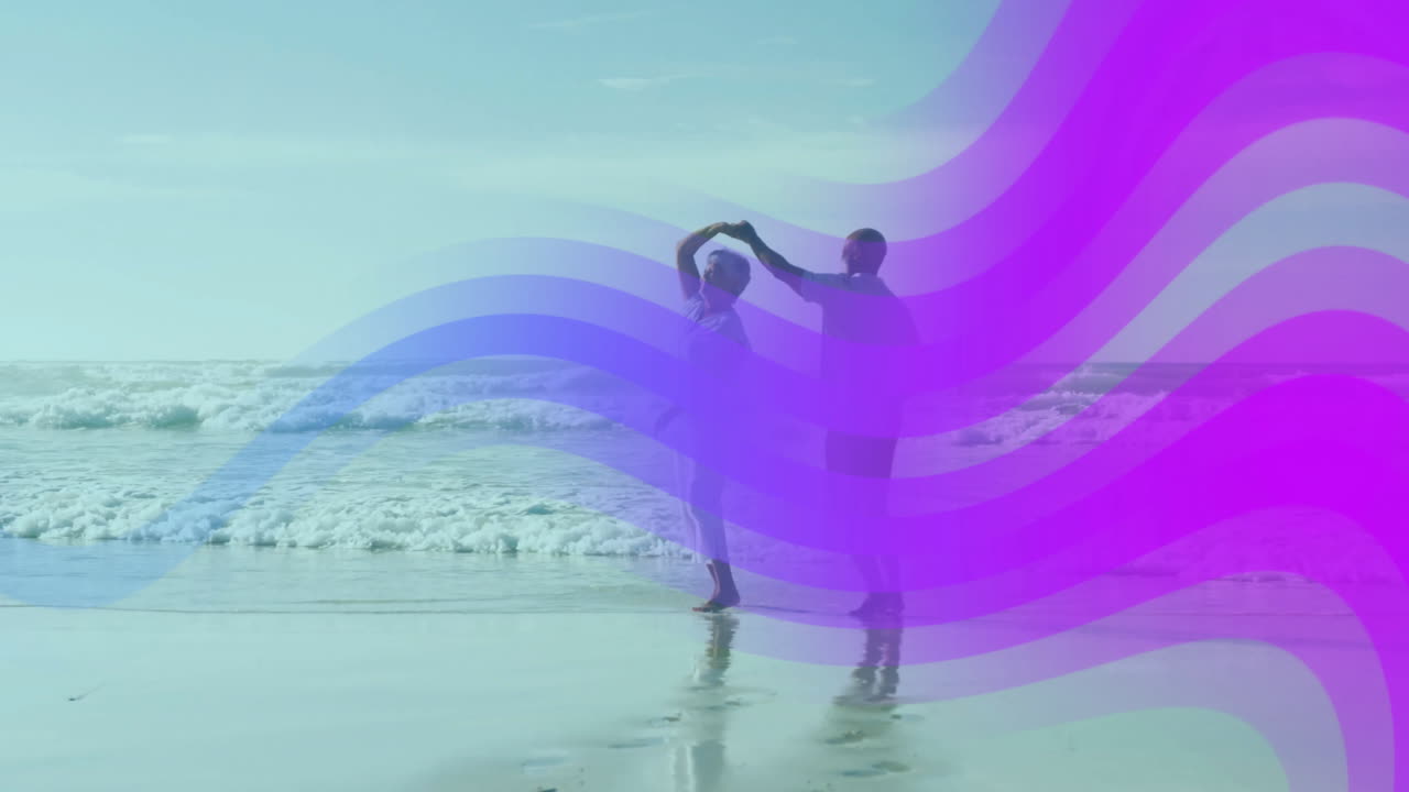 Elderly couple dancing joyfully on beach with colorful wave animation overlay