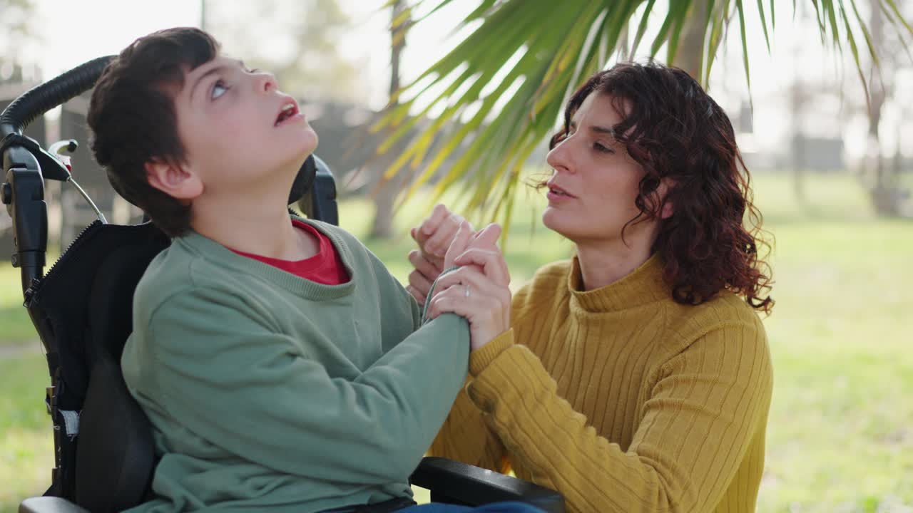 Mother and son with cerebral palsy enjoying time outdoors in wheelchair