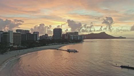 Aerial-view-of-paddleboard-rider-during-ocean-sunrise-rising