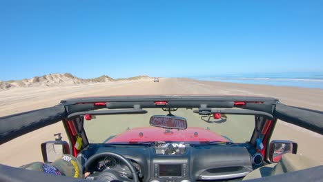 pov from the roof-top while driving on the beach with sand dunes on barrier island of the gulf of mexico - south padre island, texas