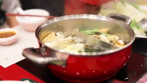 simmering hotpot with vegetables and broth