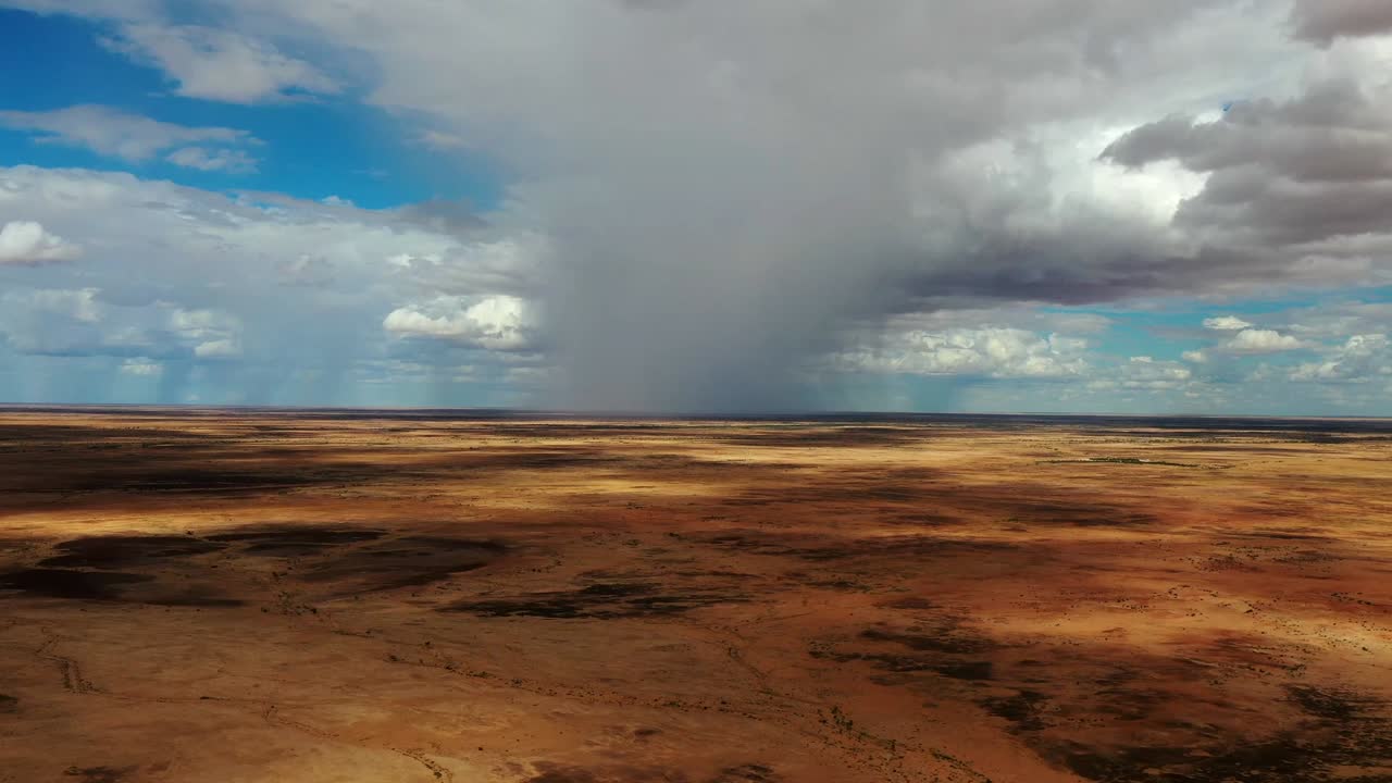 Filmagem de drone de um aguaceiro sobre a planície seca do outback do Oeste de Queensland