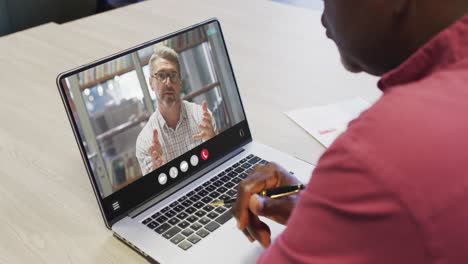 African-american-man-using-laptop-for-video-call,-with-business-colleague-on-screen