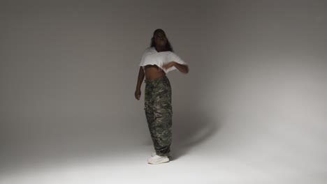 Full-Length-Studio-Portrait-Shot-Of-Young-Woman-Dancing-With-Low-Key-Lighting-Against-Grey-Background-3