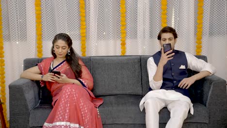 Indian-couple-using-phones-individually