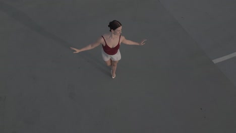 drone orbiting a ballet dancer on.a parkade roof