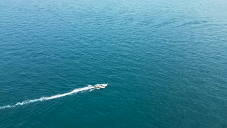 Bote-De-Cola-Larga-Que-Llega-A-La-Bahía-De-Mango-Isla-De-Ko-Tao-Costa-De-Tailandia-Con-Península-Rocosa,-Toma-Aérea-A-La-Derecha