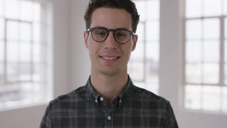 retrato en primer plano de un atractivo joven hipster con gafas sonriendo confiado disfrutando de un estilo de vida exitoso movimiento hombre independiente en las ventanas del apartamento fondo