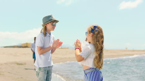 dos chicas jugando en la playa.