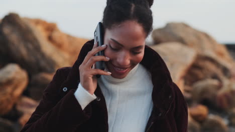 una chica afroamericana hablando por teléfono móvil.