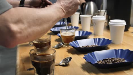 Spülen-Von-Löffeln-Während-Des-Kaffeeschröpfens-Oder-Der-Tassenverkostung,-Zeitlupe-Aus-Nächster-Nähe