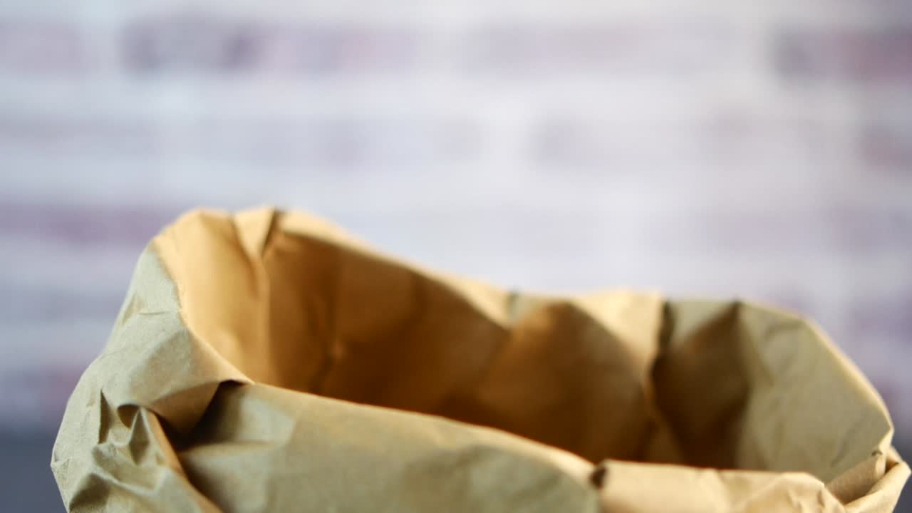 Green Apple Dropped into a Brown Paper Bag