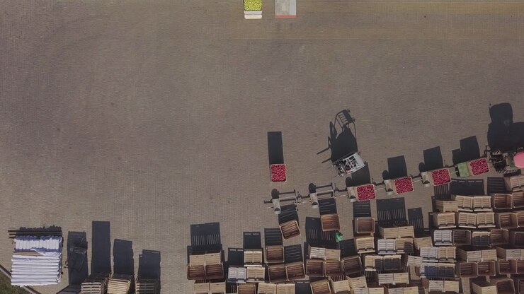 Forklift loading truck with containers full of apples. Fruits and food distribution to the large warehouse. Aerial view