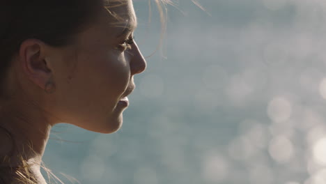 close-up-of-young-caucasian-woman-enjoying-calm-summer-day-on-ocean-seaside-relaxing-wind-blowing-hair-looking-pensive-contemplative