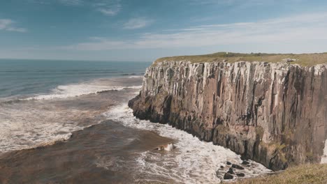 waves crashing on high brazilian cliffs on atlantic ocean, guarita park, brazilian conservation unit, rio grande do sul, torres city