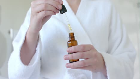 caucasian woman taking sample of oil in bathroom in slow motion