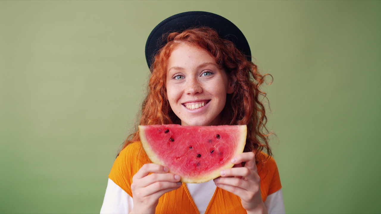 Young woman holding a watermelon slice