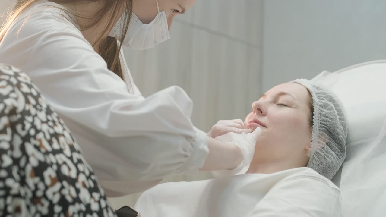 美容師の診療所で顔の治療を受けている女性