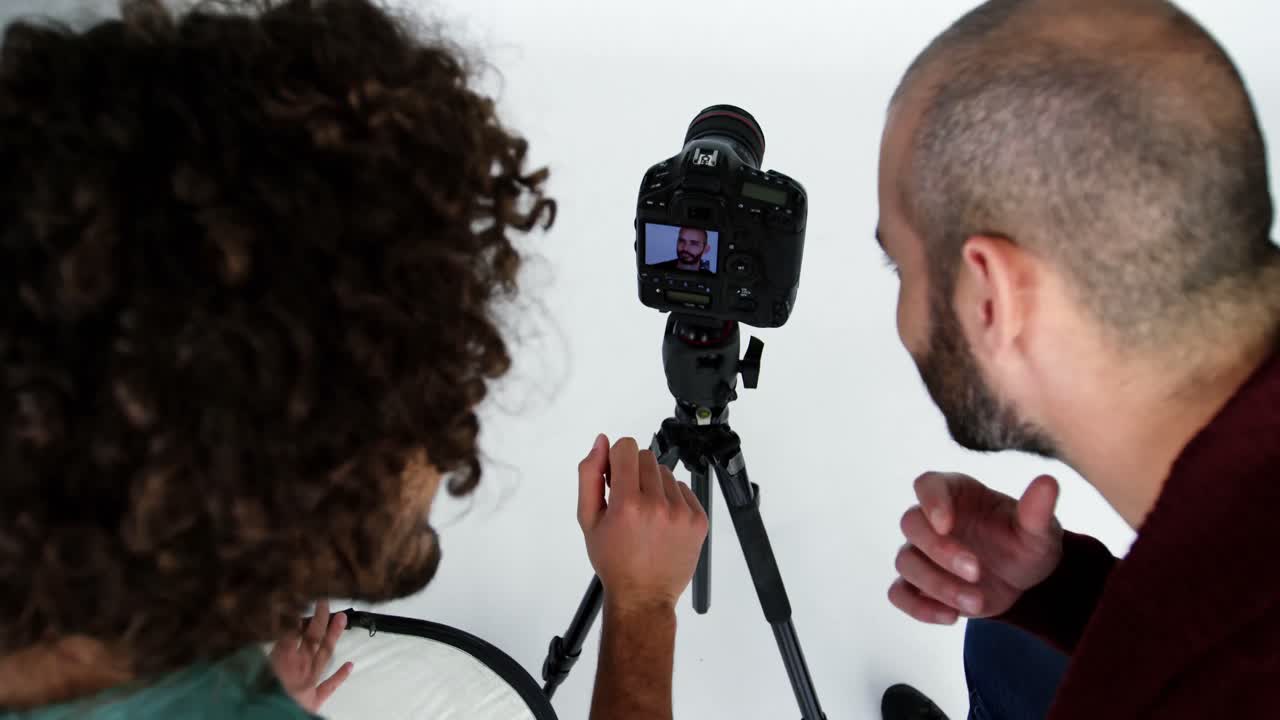 fotógrafo mostrando fotos a un modelo de moda