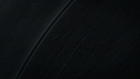 vinyl record in macro, with grooves, gaps between tracks and slight scratches - top view, slow motion