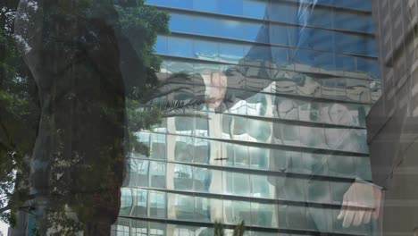 mid section of businessman and businesswoman shaking hands against tall buildings in background