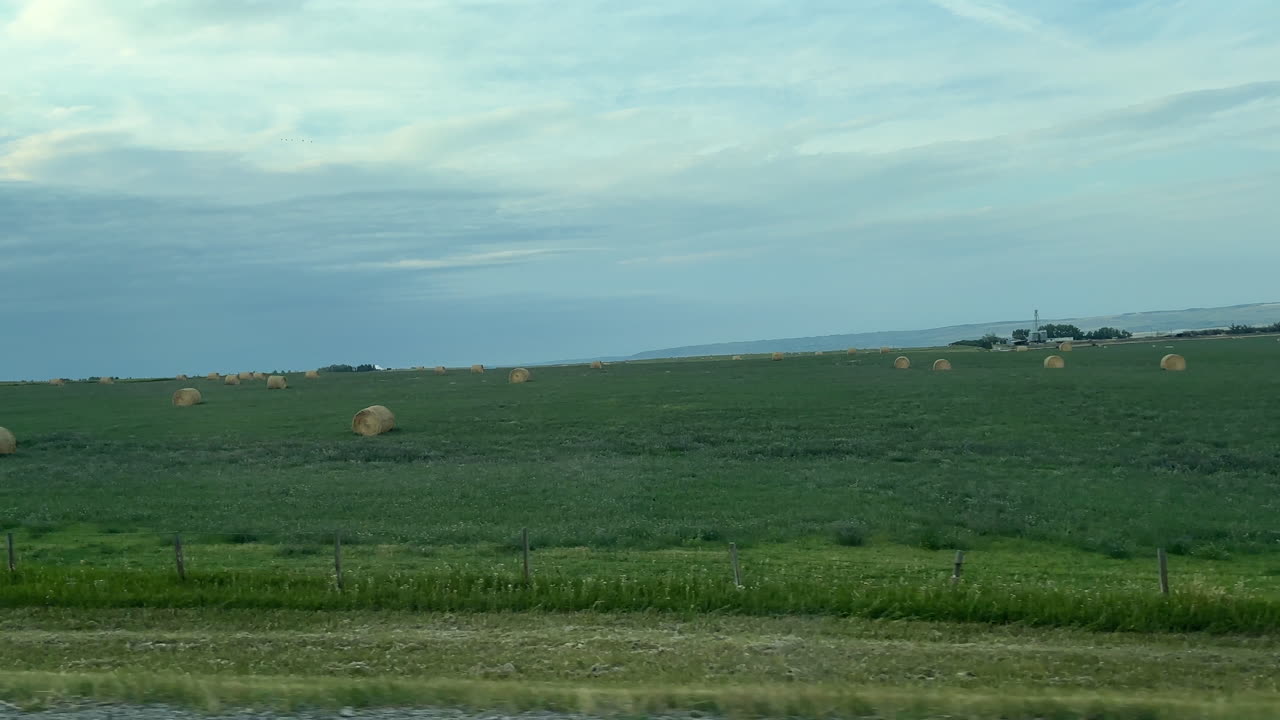 Serene Rural Landscape with Hay Bales and Green Fields