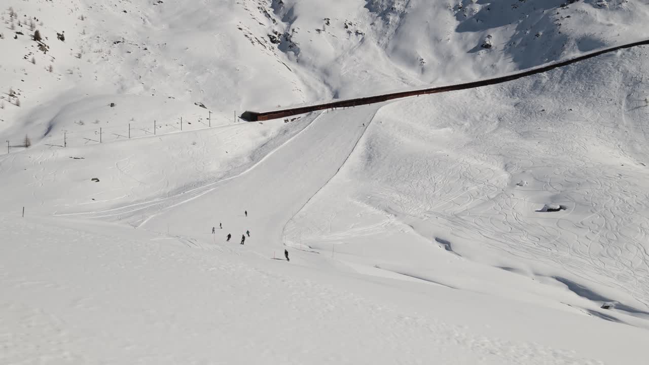 Skiers skiing down a mountain slope in ski resort, wide establisher slider