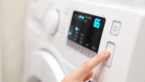 close-up of a person using a modern washing machine