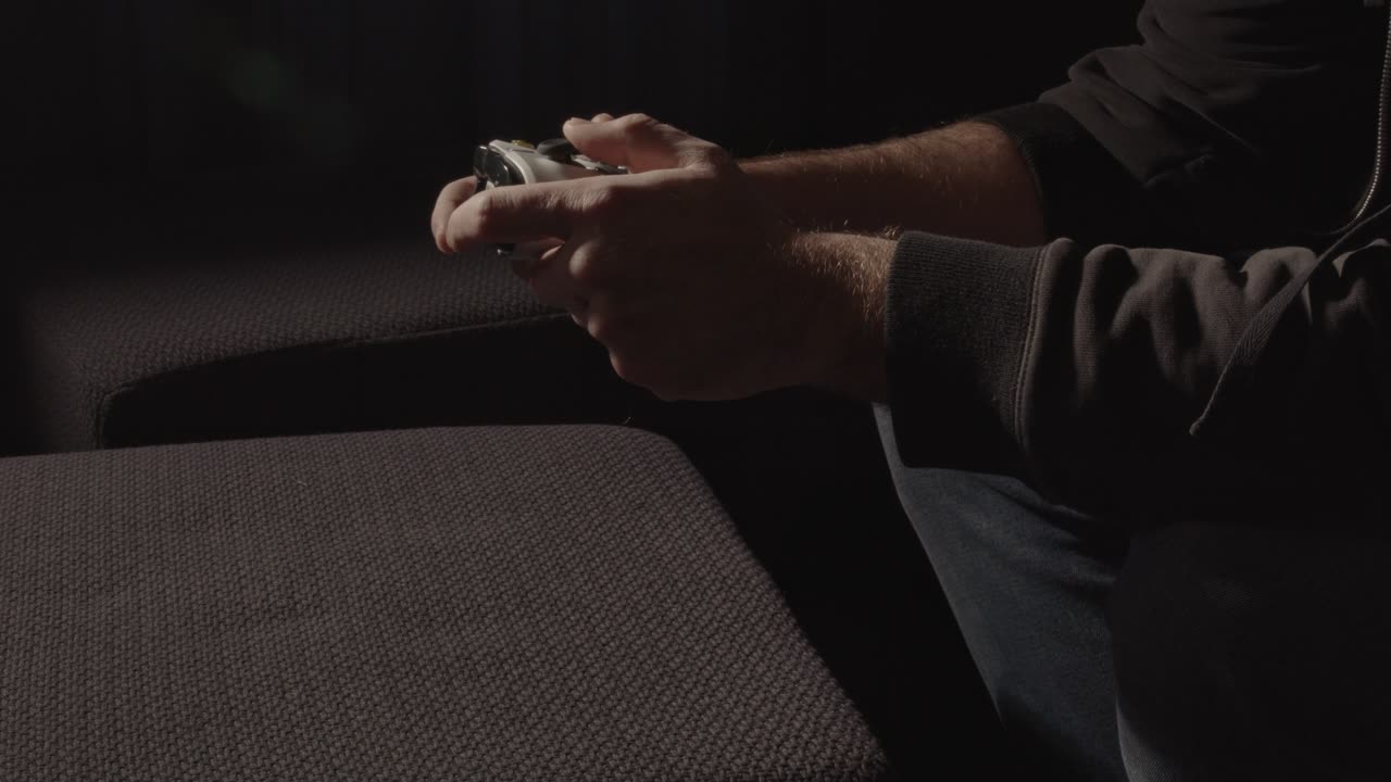 Wide view of male hands playing with videogame controller and dropping controller in frustration