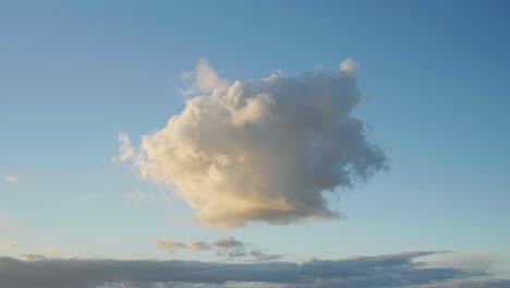 toma cinematográfica en cámara lenta de 4k de una gran nube redonda sola en el cielo durante la puesta de sol