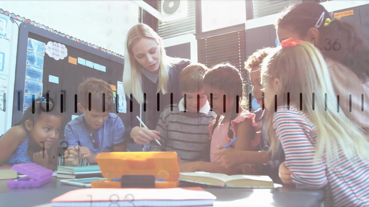Teacher leaning and pointing stylus, initiating lesson, guiding students studying tablet and book